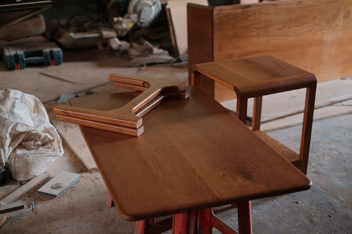 Oak table frames standing on a workshop floor before oiling